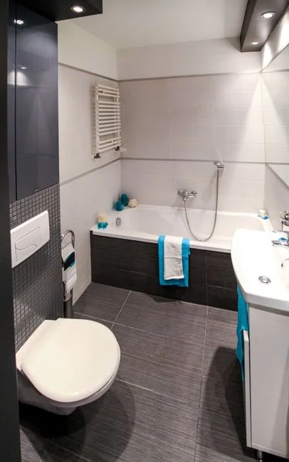 From above anonymous housekeeper in yellow rubber gloves spraying cleaner to chrome water faucet in bathroom